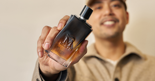 A man holding a bottle of Morph fragrance.