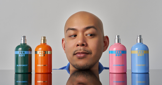 A man looking at the colorful bottle of PERROY Parfum.