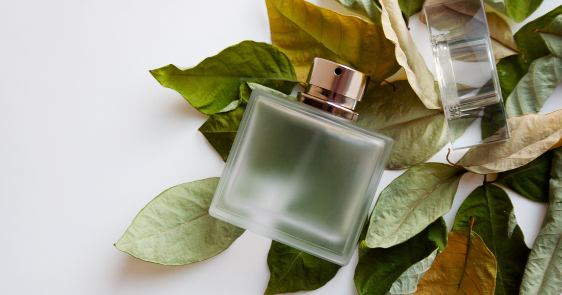 A fougere frangrance is a opaque bottle laying on a bed of leaves.