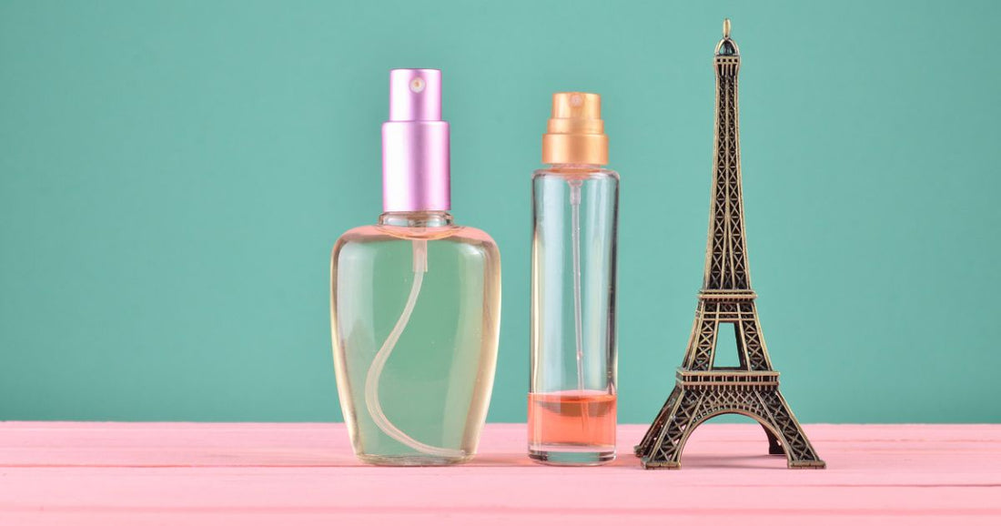 Two perfume bottles filled with French perfume next to the Effiel Tower.