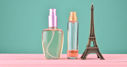 Two perfume bottles filled with French perfume next to the Effiel Tower.